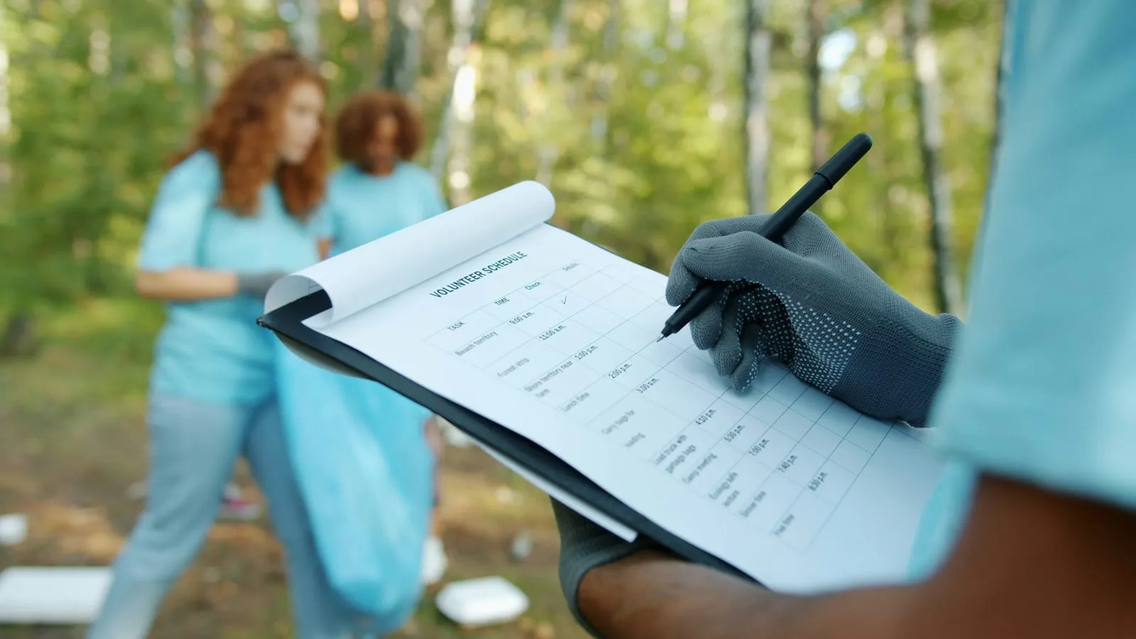 A volunteer filling in a survey on a clipboard during a litter pick